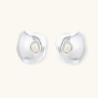 Organic silver stud earrings with white resin pearl centers in fluid stone-like shapes on light background.
