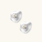 Organic silver stud earrings with white resin pearl centers in fluid stone-like shapes on light background.
